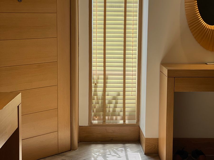 Tall window with warm wood blinds